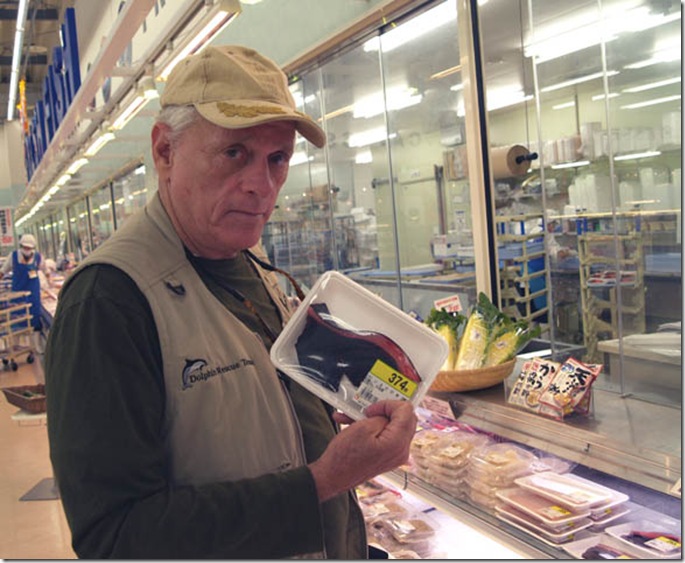 Ric O'Barry tenant une barquette de viande de dauphin dans un supermarché de Taiji - Photo d'Hélène O'Barry